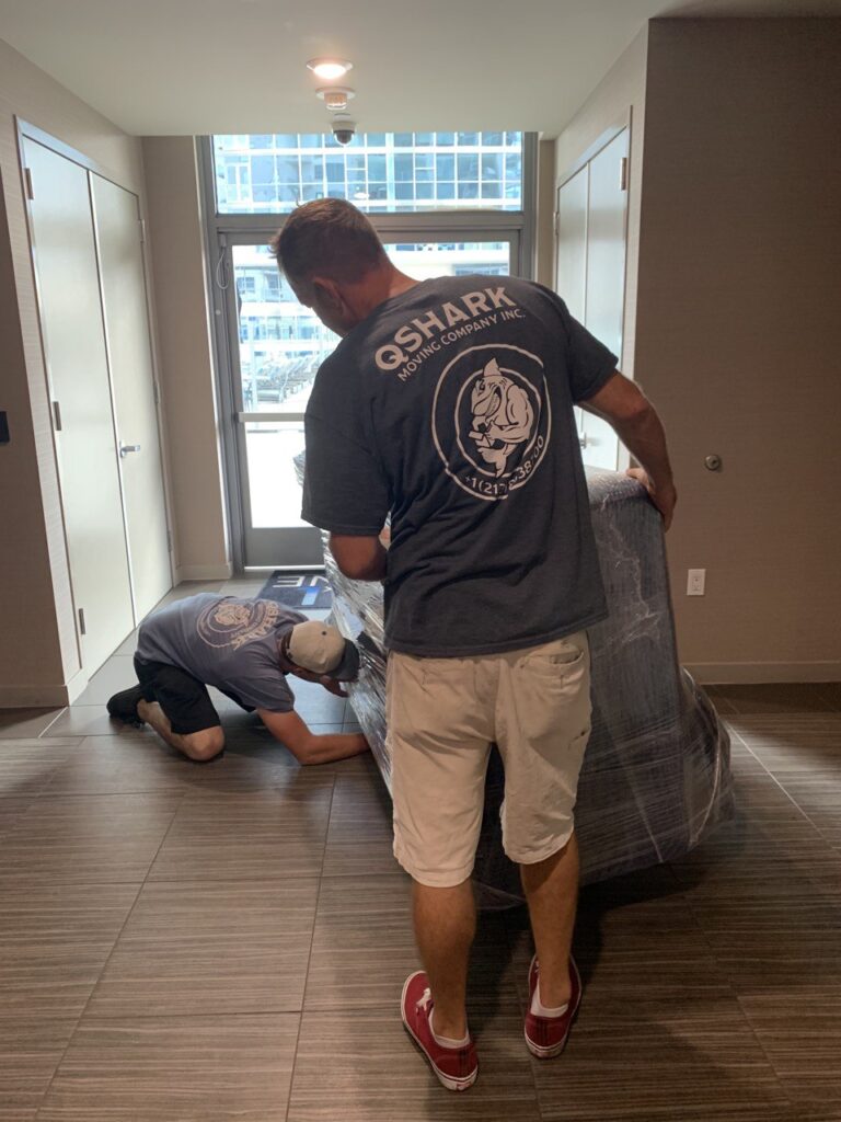 Movers carefully packing household items into boxes.
