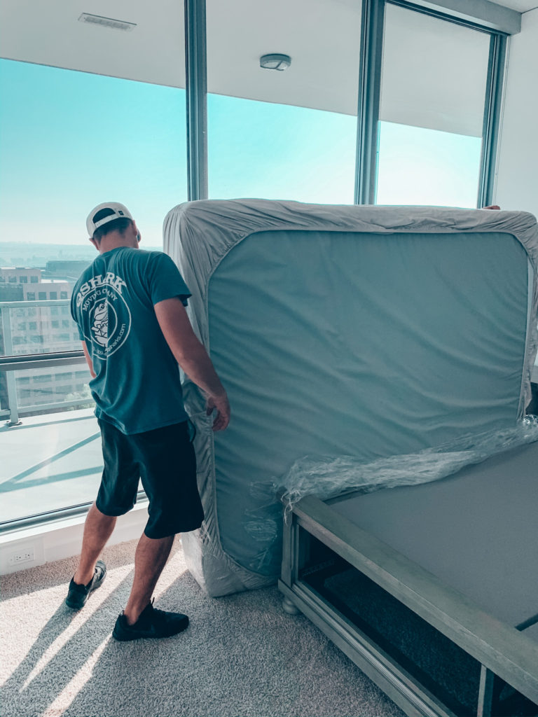 Local movers are delivering a mattress to its new home. 