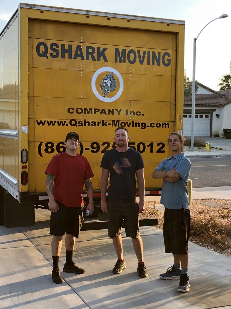 Happy customer and movers next qshark moving truck, getting loaded for a long distance relocation. 