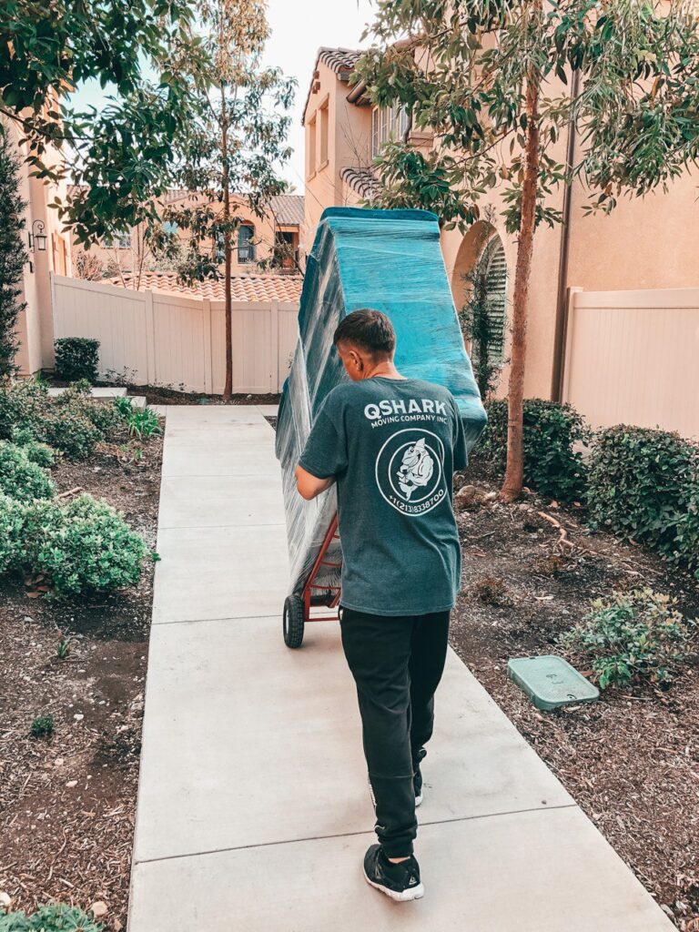 professional mover using a dolly to move a dresser