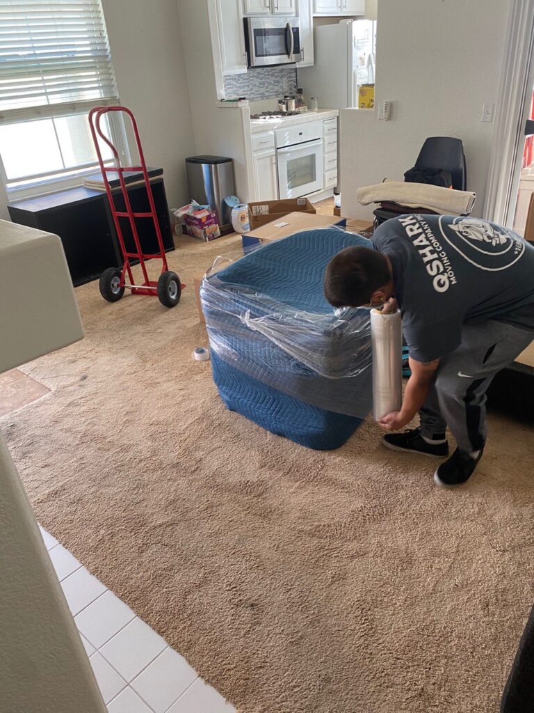movers packing furniture before moving