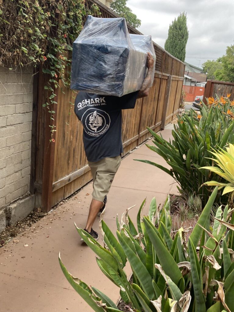 professional mover moving a tv stand