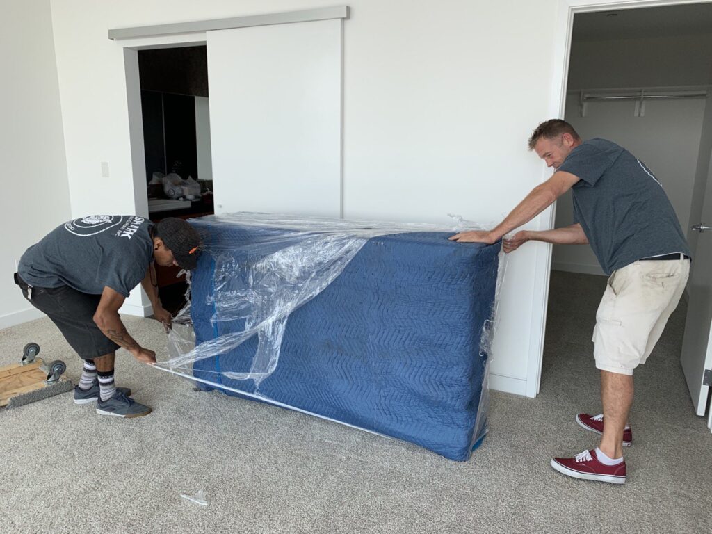 Movers unloading a dresser into the room