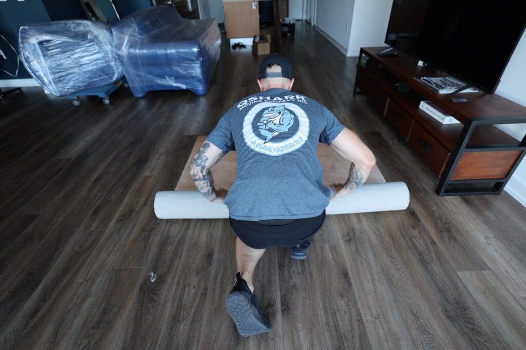 a movers prepraing a rug for moving
