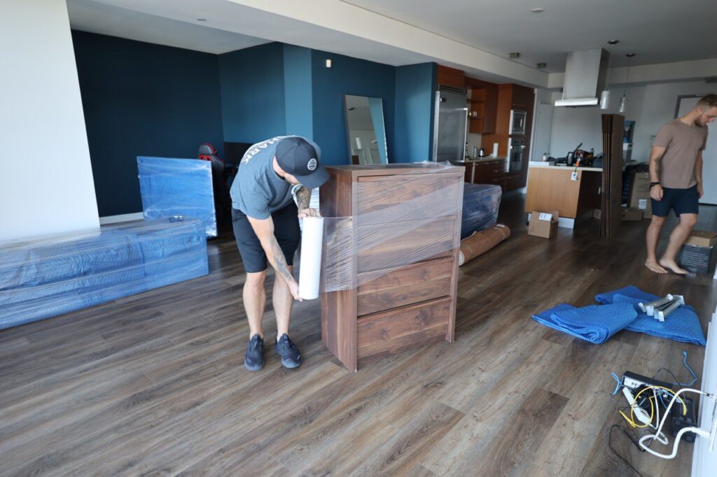 Movers are preparing dresser to be moved