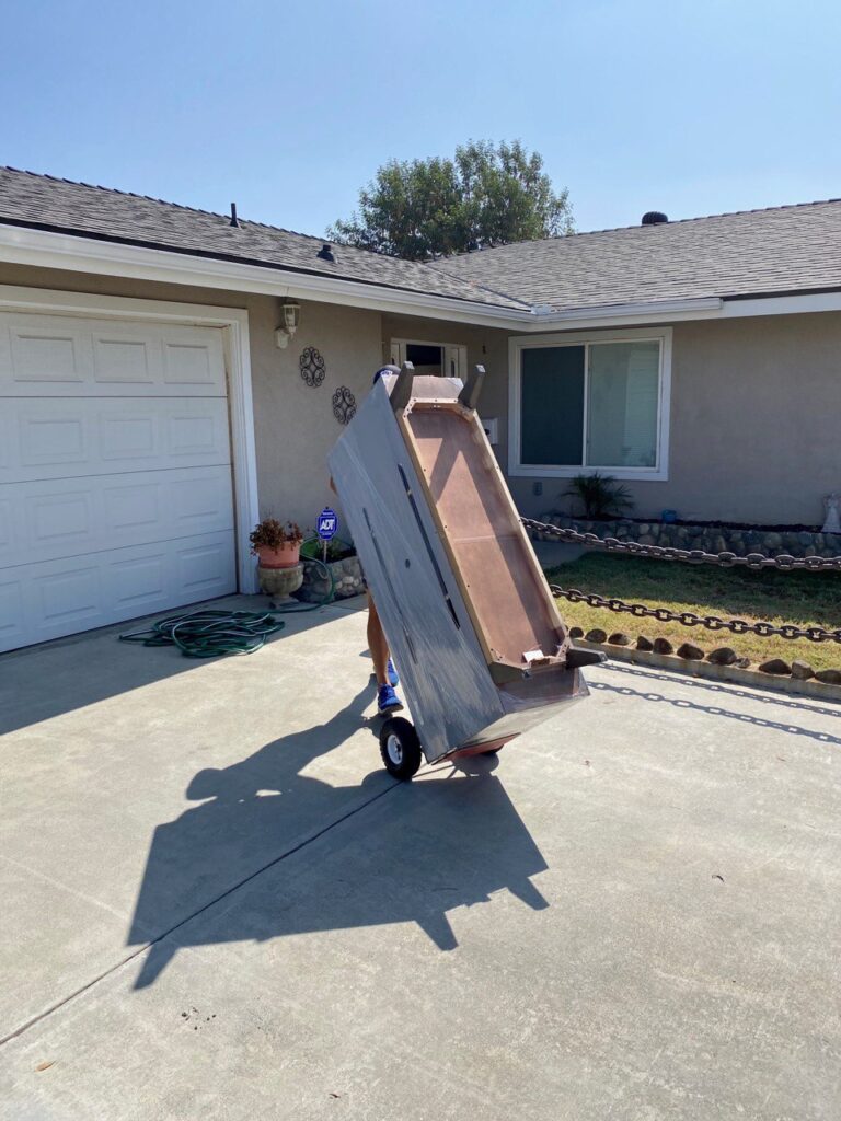 a movers using a dolly to move a dresser