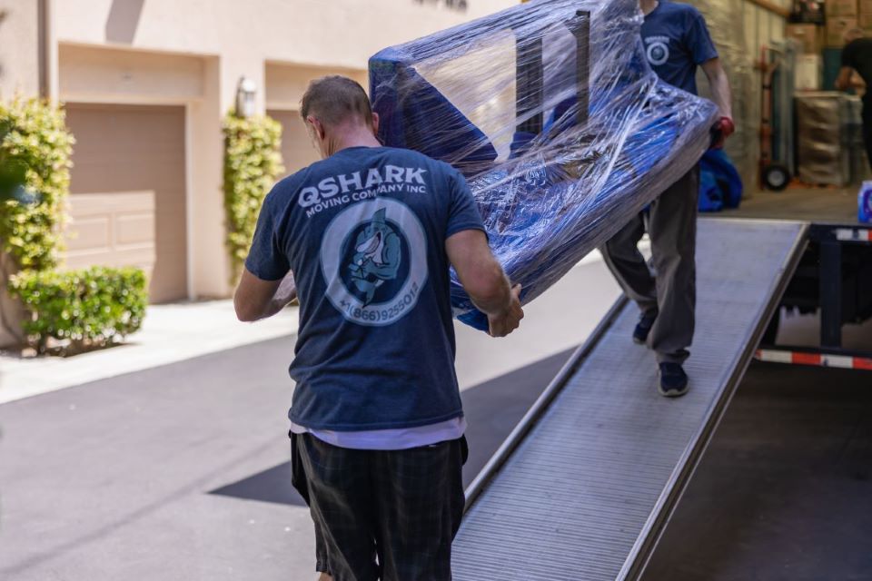 a picture of movers moving a couch from the truck