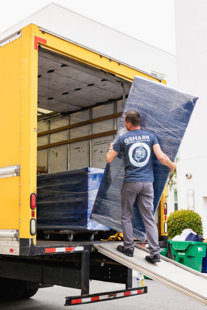 a pciture of qshark movers loading a large mirror into the moving truck