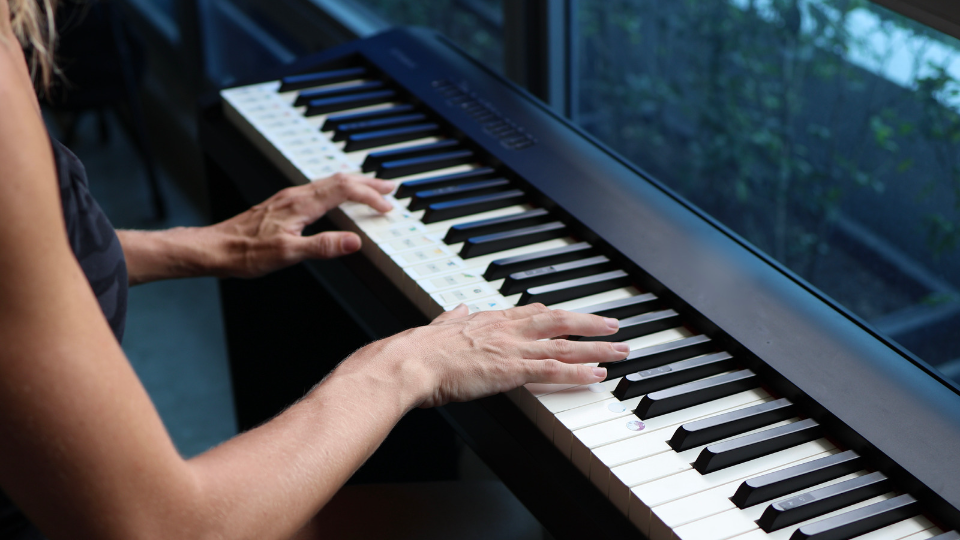 person playing a digital piano
