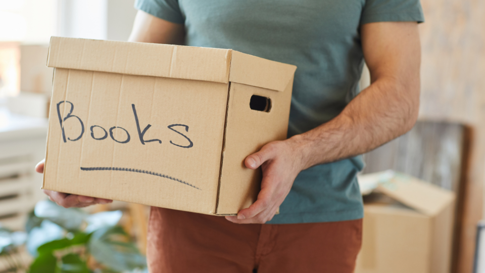 a picture of a person carrying a box saying books