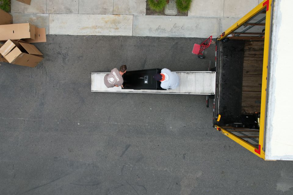 A picture of qshark movers unloading a safe from a moving truck