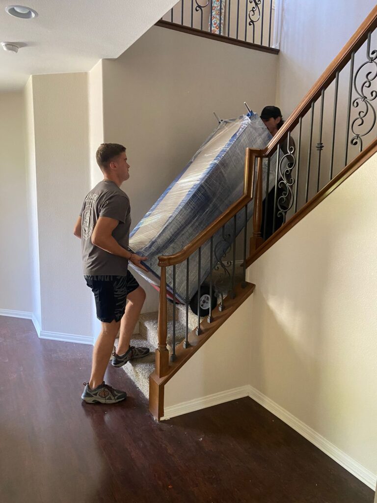 qshark movers moving an antique items up the stairs