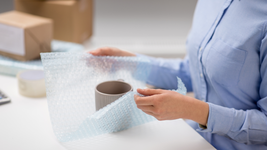 a person wrapping a mug for moving