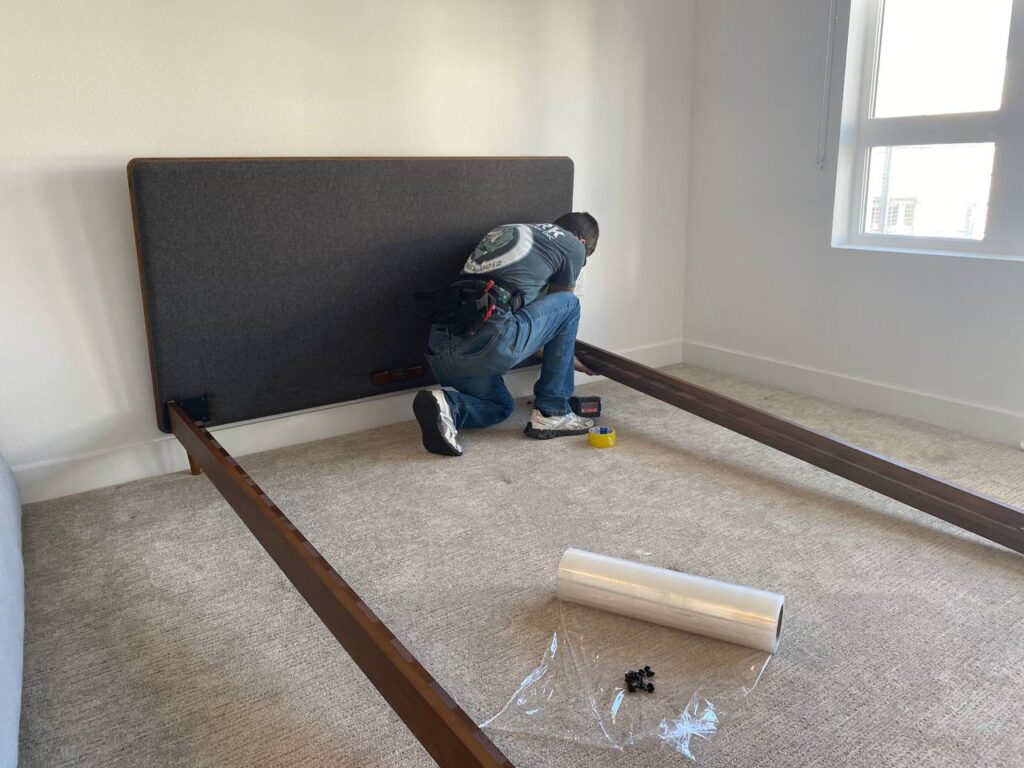 a mover taking apart a bed 