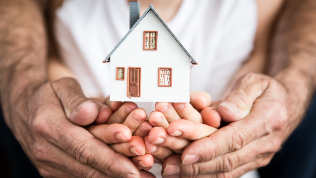 A picture of a person holding a house