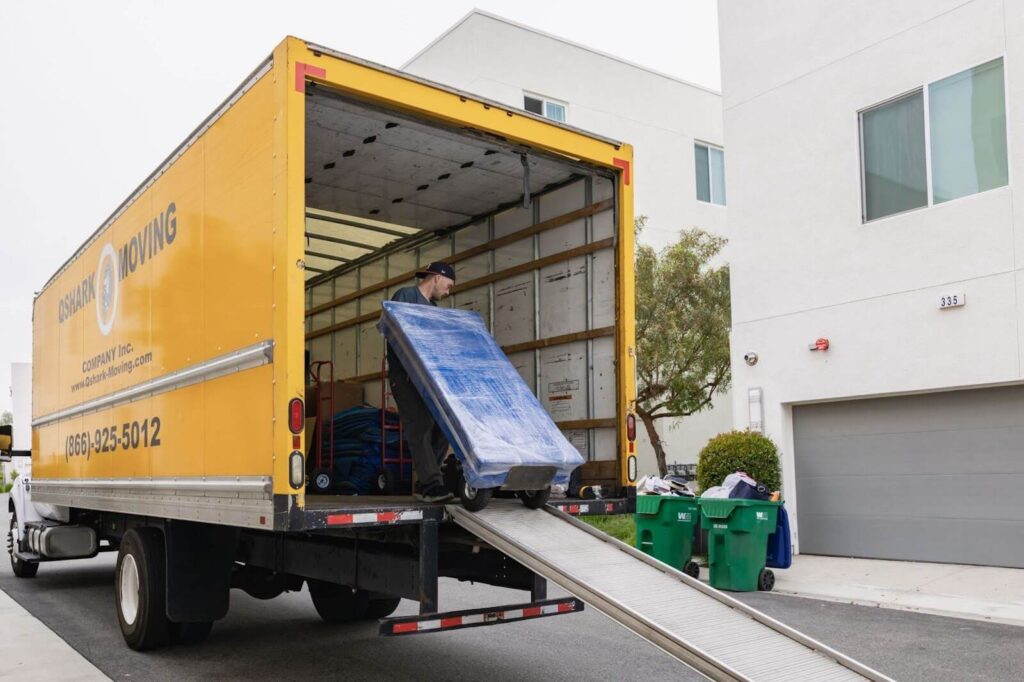 Qshark professional mover loading a bulky item on the moving truck